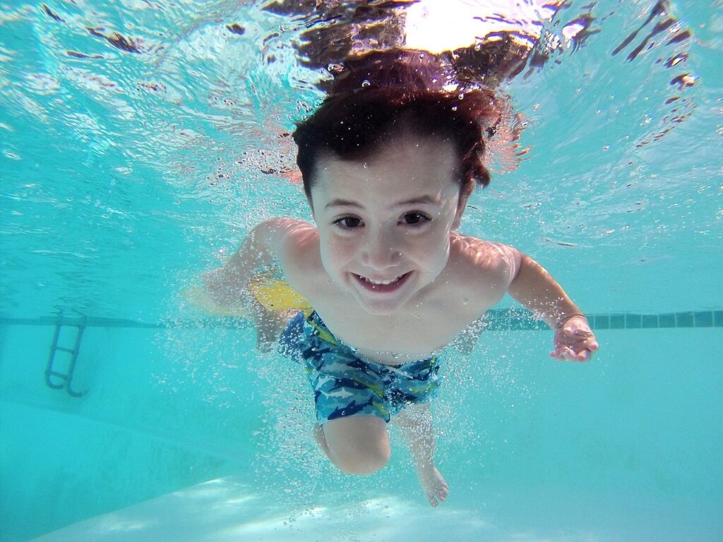 Junge unter Wasser beim Schwimmen lernen