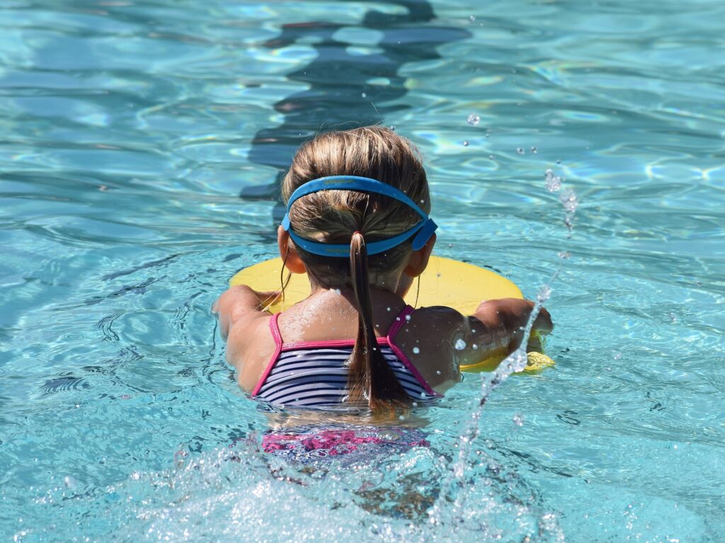 Mädchen übt das Schwimmen mit einem Schwimmbrett